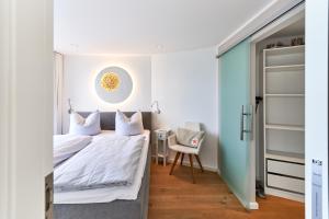 a bedroom with a bed and a chair at Sea View Suite in Scharbeutz