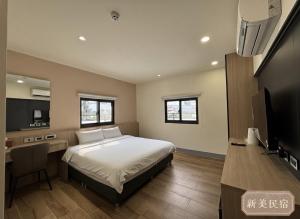 a bedroom with a bed and a flat screen tv at Shin Mei B&B in Puli