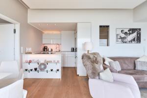 a living room with a couch and a kitchen at Sea View Suite in Scharbeutz
