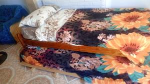a bed with a floral comforter on it at ApartCarina in General Acha