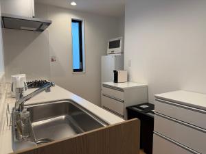 a kitchen with a sink and a refrigerator at 蔵 The KURA in Urayasu +47 photos
