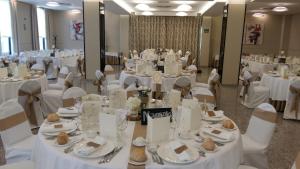 a room full of tables and chairs with white table settings at Ponferrada Plaza in Ponferrada