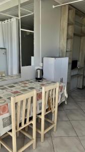 a kitchen with a table and chairs and a refrigerator at Pousada Azambuja in Cidreira +2 photos