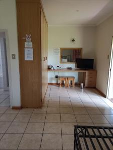 a room with a kitchen with a counter and a table at Ingwe Guest lodge in Vanderbijlpark