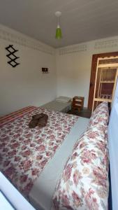 a bedroom with a large bed with a flower blanket at Casa da Piscina in Maceió +1 photo