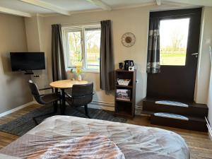a bedroom with a bed and a desk and a television at B&B Warnstee in Wichmond