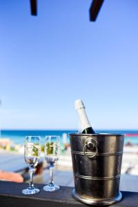 a bucket of champagne and two glasses on a table at the beach at Acuario Pousada in Arraial do Cabo