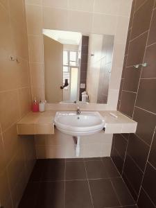 a bathroom with a sink and a mirror at Setia Alam Urban Rooms in Shah Alam