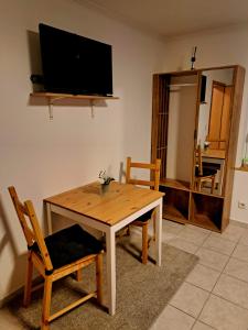 a living room with a wooden table and a television at Pension Müller in Barweiler