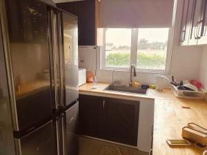 a kitchen with a refrigerator and a sink and a window at Setia Alam Urban Rooms in Shah Alam +21 photos