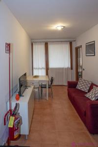 a living room with a red couch and a table at Casa da Luna in Parma +14 photos