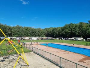 a pool with people playing in it in a park at Camping San Lanaco in Lanaken