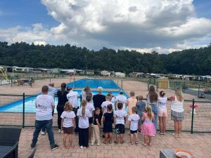 a group of children standing in front of a pool at Camping San Lanaco in Lanaken