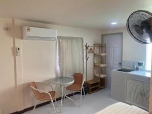 a kitchen with a table and chairs and a sink at Aiem-Wilai Guesthouse in Suratthani