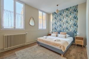 a bedroom with a bed with a blue wall at Jeanne d'Arc - Plage à pied - Central in Villerville