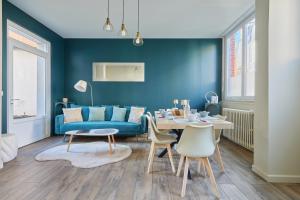 a blue living room with a table and a blue couch at Jeanne d'Arc - Plage à pied - Central in Villerville +6 photos