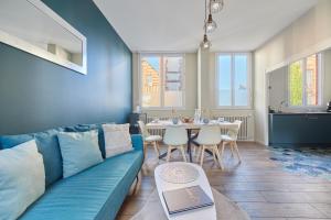 a living room with a blue couch and a table at Jeanne d'Arc - Plage à pied - Central in Villerville