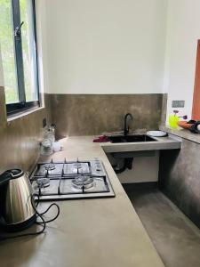 a kitchen with a stove and a sink at Mama Place in Hikkaduwa