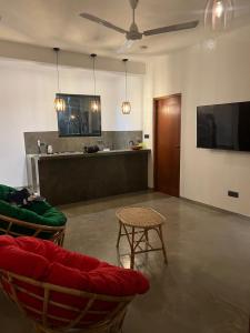 a living room with chairs and a television and a table at Mama Place in Hikkaduwa