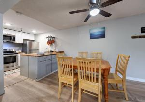 a kitchen with a table with chairs and a ceiling fan at Thunderhead Lodge Condo 204 - Modern Heated Pool & Games in Government Camp