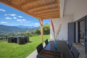 a patio with a table and chairs and a view at Casa Bianca in LʼÎle-Rousse