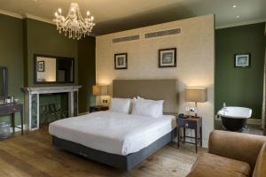 a bedroom with a bed and a bathroom with a sink at Stoke Place- Part of the Cairn Collection in Slough