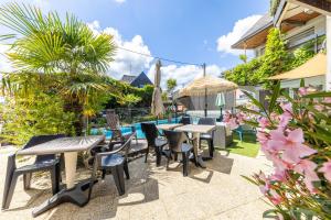 a patio with tables and chairs next to a pool at Ouest Découvertes in Crozon