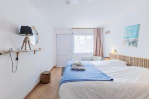 a bedroom with a bed with a blue blanket on it at Ouest Découvertes in Crozon
