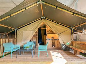 a tent with chairs and a table in it at Camping San Lanaco in Lanaken
