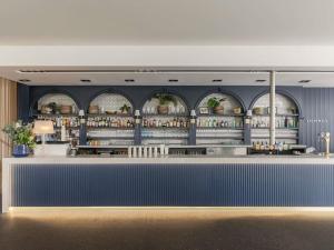 a bar with blue walls and arched windows at Peppers Blue on Blue in Nelly Bay