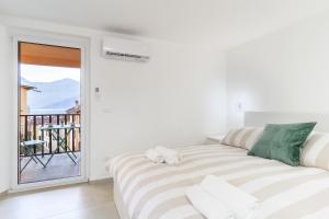 a white room with a bed and a balcony at La Casa sulla Cascata in Colonno