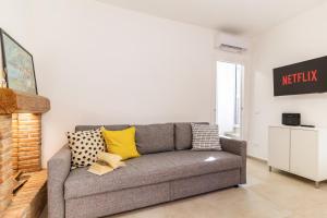 a living room with a gray couch with yellow pillows at La Casa sulla Cascata in Colonno