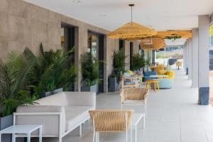a lobby with white furniture and chairs and plants at Stephouse Pozuelo Europa in Madrid