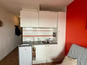 a small kitchen with white cabinets and a sink at Studio cabine première ligne in Fleury +5 photos