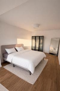 a bedroom with a large bed with white sheets at Seeblick-Apartment am Bodensee bei Konstanz mit großer Terrasse in Reichenau