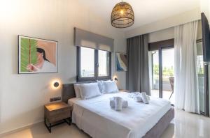 a bedroom with a large white bed and a balcony at Helios Blue Villas Kriopigi Kassandra in Kriopigi +52 photos