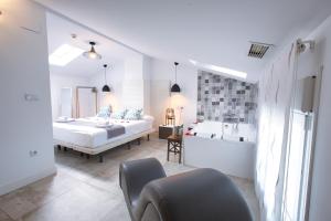 a bedroom with a bed and a tub and a sink at Apartamentos Cabañas in Carboneras de Guadazaón
