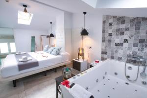 a bedroom with a bed and a tub in a room at Apartamentos Cabañas in Carboneras de Guadazaón