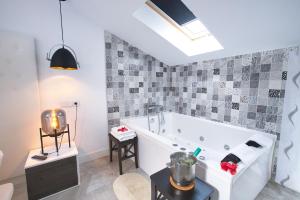 a bathroom with a white tub in a room at Apartamentos Cabañas in Carboneras de Guadazaón