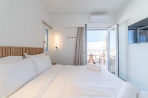 a bedroom with a large white bed and a balcony at Elia serenity apartment 4 in Mesochórion +23 photos