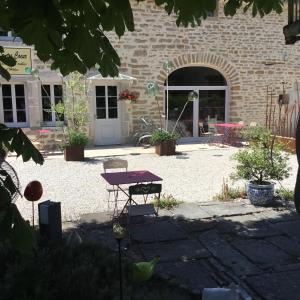 a patio with a table and chairs in front of a building at L'Entre-Coeur in Ménétru-le-Vignoble +19 photos