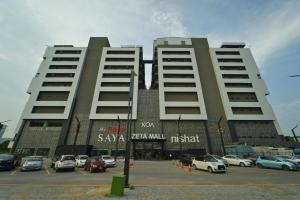 a large building with cars parked in a parking lot at Premium 3BHK with UPS, across Giga Mall, Pool Included in Islamabad