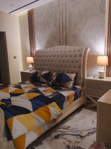 a bedroom with a large bed and a night stand at Premium 3BHK with UPS, across Giga Mall, Pool Included in Islamabad