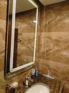 a bathroom with a sink and a large mirror at Premium 3BHK with UPS, across Giga Mall, Pool Included in Islamabad +12 photos