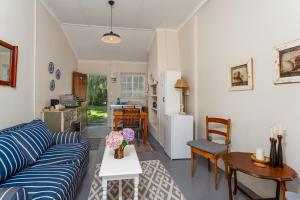 a living room with a couch and a table at Honeyrock Cottages in Kleinmond