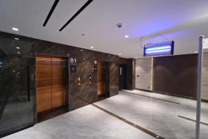 a lobby with a elevator and a sign on the wall at Premium 3BHK with UPS, across Giga Mall, Pool Included in Islamabad