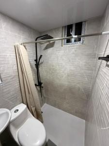 a white bathroom with a toilet and a sink at Moon Apartamento C2 in San Cristóbal