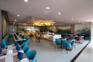 a restaurant with blue chairs and tables and a bar at Coral Reef Kakkanad in Cochin