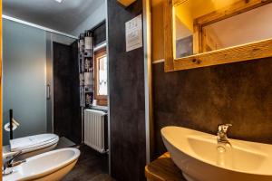 a bathroom with a sink and a toilet at Chalet Saint-Barthélemy Hotel in Nus +57 photos