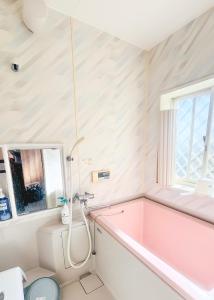a bathroom with a pink tub and a window at SORA Blue House, 海辺の隠れ家, ペットBBQ可, 全3寝室&リビングオーシャンビュー,一棟貸切 in Hokota +24 photos